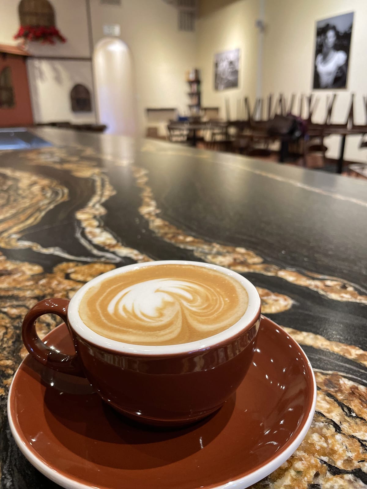 A latte with heart-shaped foam art on the marble counter